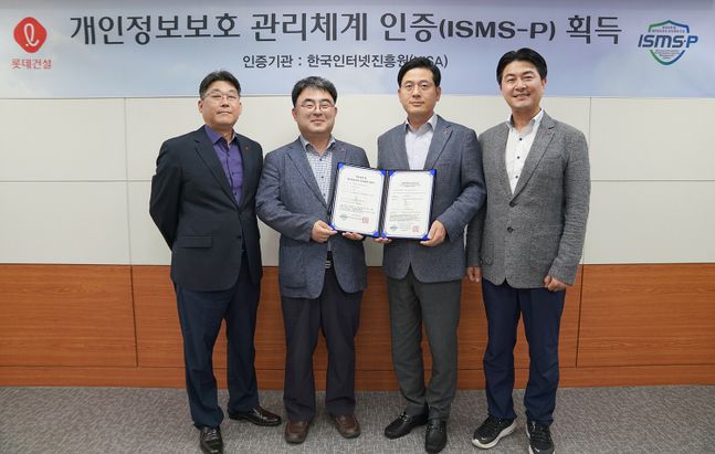 롯데건설 정보보호 관계자들이 ISMS-P 인증서를 들고 촬영하고 있다.ⓒ롯데건설