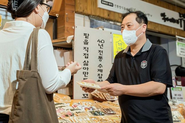 쿠팡이츠 배달파트너에게 떡을 전달하는 김남수 명가떡집 사장. ⓒ쿠팡이츠