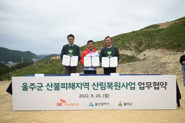 26일 울산 울주군 대복리 산불피해 현장에서 열린 'SK 울산 행복의 숲' 조성을 위한 업무협약식에서 (왼쪽부터)이순걸 울주군수, 김두겸 울산광역시장, 김준 SK이노베이션 부회장이 협약서를 들고 기념촬영을 하고 있다.ⓒSK이노베이션