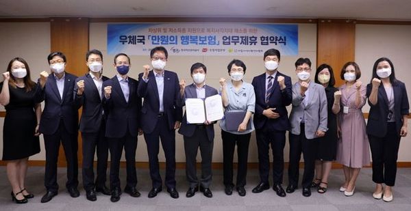 지난달 30일 서울시 중구 소재 서울지방우정청 중회의실에서 열린 협약식에 참석한 신흥식 한국자산관리공사 부사장(사진 왼쪽에서 다섯번째)이 관계자들과 함께 기념촬영을 하고 있다.ⓒ한국자산관리공사