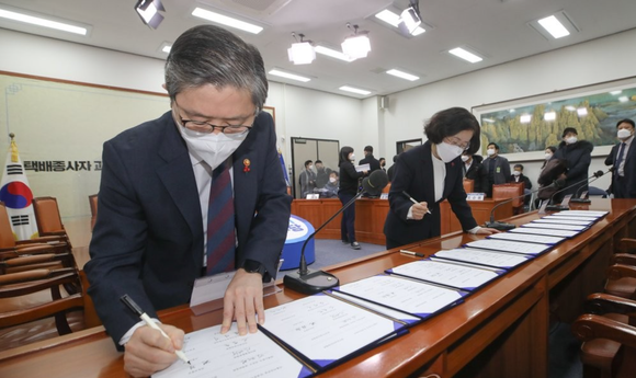 변창흠 국토교통부 장관과 조성욱 공정거래위원장이 21일 오전 서울 여의도 국회에서 열린 더불어민주당 민생연석회의 택배종사자 과로대책 사회적 합의기구 1차 합의문 발표식에서 합의문에 서명하고 있다.ⓒ공동취재사진단