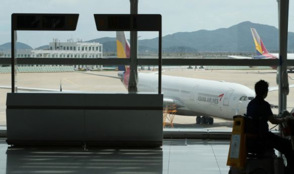 영종도 인천국제공항 제1터미널 텅 빈 여행사 카운터 너머로 보이는 항공기.ⓒ연합뉴스