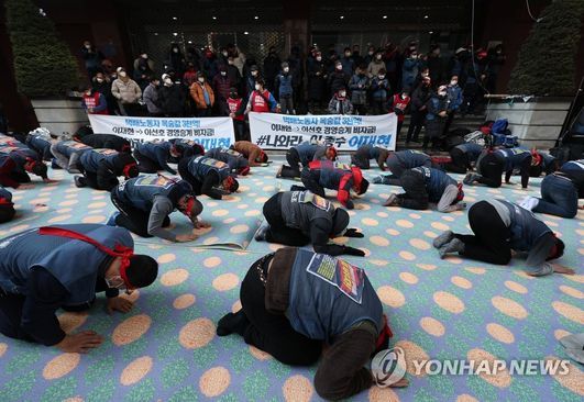 CJ대한통운 택배노조 조합원들이 점거 농성 사흘째인 12일 오전 서울 중구 CJ대한통운 본사 앞에서 대화를 촉구하고 파업 사태의 조속한 해결을 위한 108배를 하고 있다.ⓒ연합뉴스