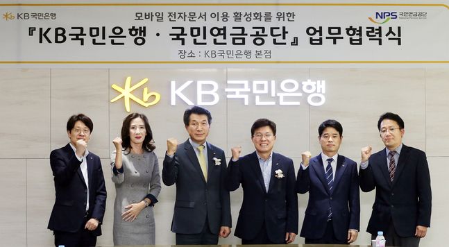 지난 4일 서울시 영등포구 KB국민은행 신관에서 열린 '모바일 전자문서 이용 활성화를 위한 업무협력식'에서 (왼쪽 세번째)성채현 KB국민은행 개인고객그룹 대표, (왼쪽 네번째)김청태 국민연금공단 디지털혁신본부장 및 양 기관 관계자가 기념촬영을 하고 있다. ⓒKB국민은행