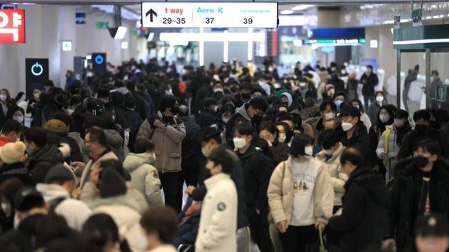 설 연휴 마지막 날인 24일 오전 폭설과 강풍이 몰아쳐 항공편이 전편 결항한 가운데 승객들이 대기표를 구하기 위해 각 항공사 대기전용 카운터에 길게 줄을 서 있다. ⓒ연합뉴스