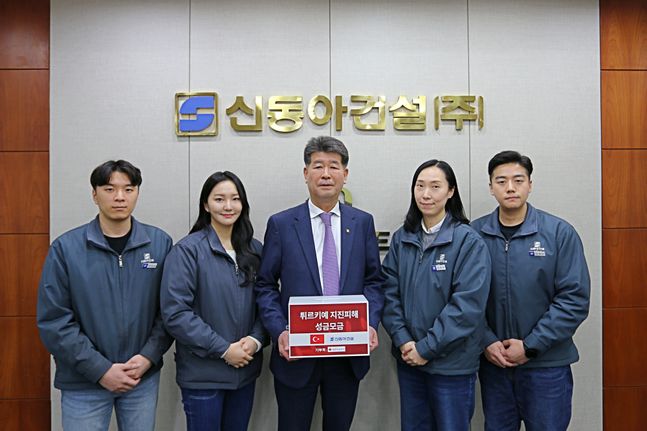 진현기 신동아건설 대표이사(가운데)가 피해복구 성금 모금함을 들고 직원들과 기념촬영을 하고 있다. ⓒ신동아건설