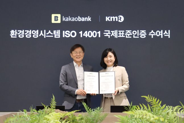 지난 17일 성남시 분당구의 카카오뱅크 판교오피스에서 열린 'ISO 14001' 인증서 수여식에서 카카오뱅크 이강원 최고 커뮤니케이션책임자(왼쪽)와 한국경영인증원 황은주 대표이사(오른쪽)가 기념 촬영하고 있다. ⓒ카카오뱅크