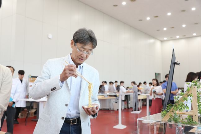 농심 신동원 회장이 사내 아이디어공모전 '챌린지페어'에서 연구원들이 만든 시제품을 시식하고 있다.ⓒ농심