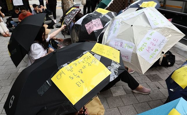 티몬·위메프의 모회사인 서울 강남구 큐텐 앞에서 피해자들이 회사 측에 빠른 환불과 대책 마련 등을 촉구하며 우산 시위를 하고 있다.ⓒ연합