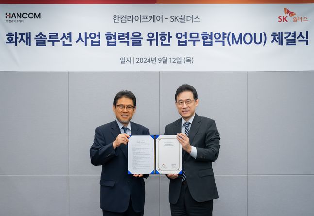 지난 12일 SK쉴더스 판교본사에서 SK쉴더스와 한컴라이프케어가 전기차 및 리튬 배터리 화재 예방 시스템 구축을 위한 협력을 진행했다. SK쉴더스 김진중 융합보안사업부장(전무, 오른쪽)과 한컴라이프케어 오병진 대표(왼쪽)가 기념 촬영을 하고 있다. ⓒSK쉴더스