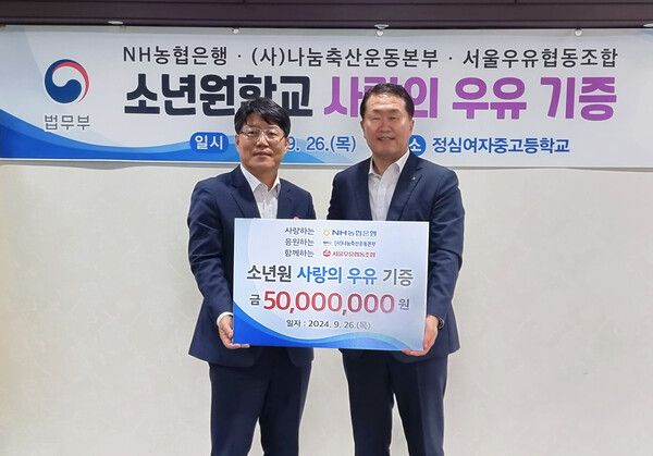 26일 정심여자중고등학교에서 열린 사랑의 우유나눔 행사에서 이영면 법무부 범죄예방정책국장(왼쪽)과김문기 농협은행부행장이 기념사진을 촬영하고 있다ⓒ농협은행