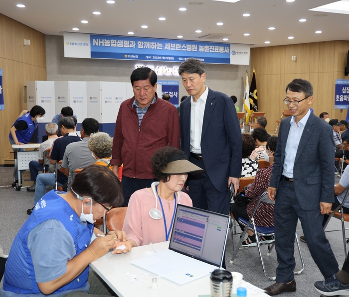 강원도 고성군 토성농협 대강당에서 김재춘 농협생명 부사장(가운데), 김명식 토성농협 조합장(왼쪽)이 검진받는 조합원을 살피고 있다. [출처= NH농협생명]