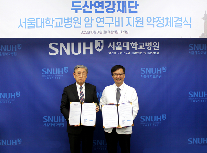 지난 30일 열린 서울대학교병원 암 연구비 지원 약정 체결식에서 두산연강재단 박용현 이사장(왼쪽)과 서울대학교병원 김영태 병원장이 기념촬영을 하고 있다. [제공=두산연강재단]