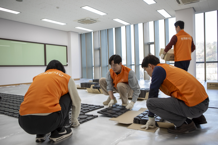 한화토탈에너지스 직원들이 서울시사회복지협의회와 함께 마포 자활센터를 방문해 바닥 난방용 온돌매트를 설치하는 모습. [제공=한화토탈에너지스]