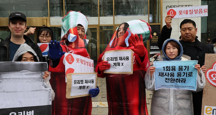 14일 오후 서울 송파구 롯데칠성 본사 앞에서 유리병재사용시민연대가 연 기자회견에서 참가자들이 롯데칠성의 유리병 재사용 목표 선언을 촉구하는 퍼포먼스를 하고 있다. [제공=연합]