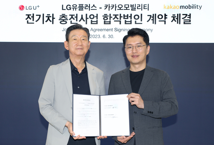 황현식 LG유플러스 대표(왼쪽)와 류긍선 카카오모빌리티 대표가 지난 6월 열린 ‘전기차 충전 사업 합작법인 계약 체결식’에서 기념촬영을 하는 모습. LG유플러스