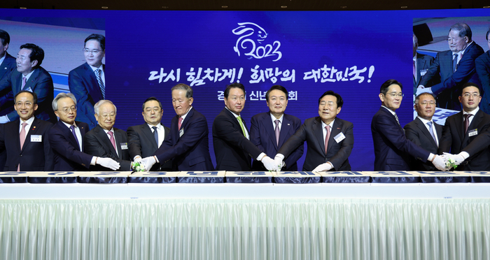 윤석열 대통령이 지난 1월 2일 서울 강남구 코엑스에서 열린 2023 경제계 신년인사회에서 참석자들과 떡을 자르고 있다. [제공=연합]