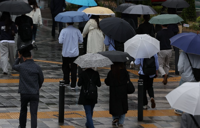 전국적으로 비가 내리면서 시민들이 우산을 쓴 채 이동하고 있다. [제공=연합]