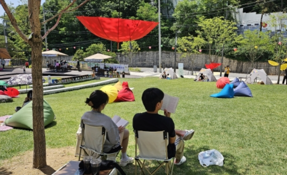 서울 광진구민들이 아차산어울림광장의 ‘광진 야외도서관’에서 책을 읽고 있다. [제공=광진구]