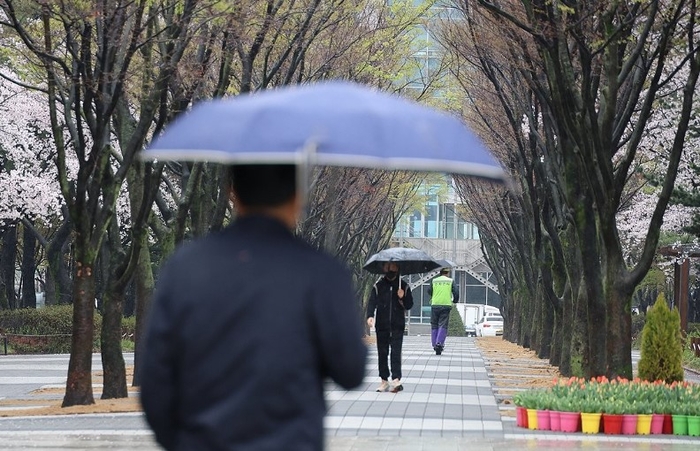시민들이 우산을 쓰고 걸어가고 있다. [제공=연합]