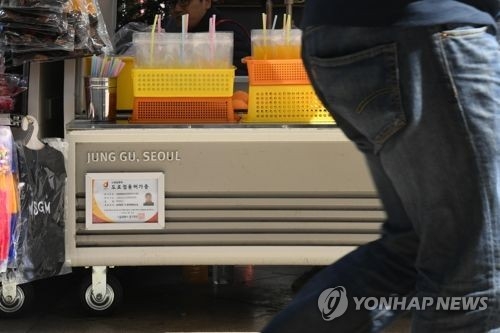 서울 명동 롯데백화점 앞 노점에 붙은 도로점용허가증. 연합뉴스