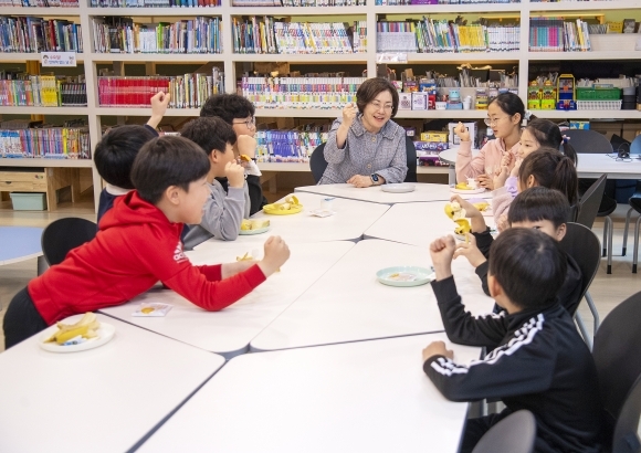 우리동네키움센터 용산 4호점에서 어린이들과 간식시간을 함께 하고 있다.(가운데)박희영 용산구청장. [제공=용산구]